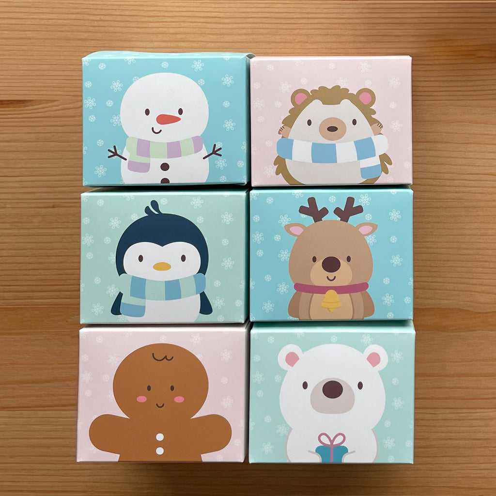 Winter Parlour Pals®, Snowman, Hedgehog, Penguin, Reindeer, Gingerbread Man, and Polar Bear, in cute little favor boxes for gifting tubs of dough on wooden table