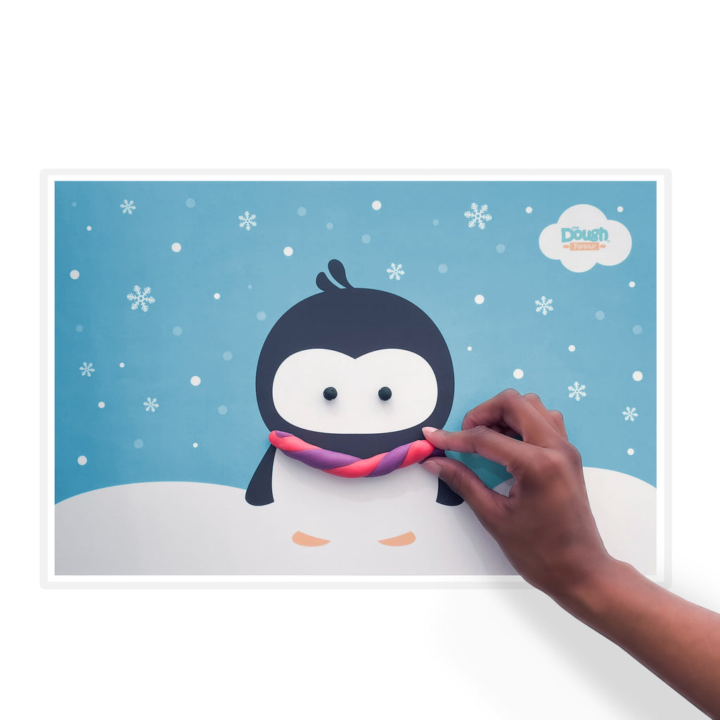 Frosty Playmat showing cute penguin getting scarf decorated with pink and purple dough twisted