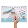 Birthday Bundle mat with silicone roller, dough in a favour box, and a child's hand forming a strawberry over the printed cake image