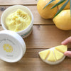 The Dough Parlour lemon scented yellow dough sculpted into a lemon wedge beside a tub of dough and real lemons