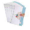 Set of 10 birthday mats fanned out. Printing shows purple and green bunting and a cake on a cake plate sitting on a blue table. A child's hand has a modelling dough strawberry placed over the printed cake image